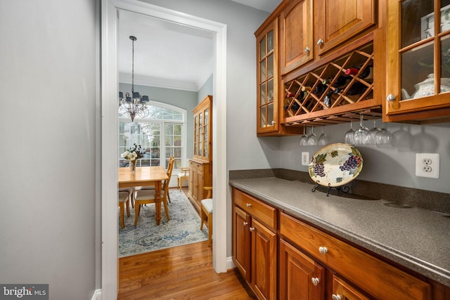 13073 Taverner Loop, Woodbridge, VA 22192 - bar featuring crown molding, a dry bar, light wood-style flooring, and an inviting chandelier