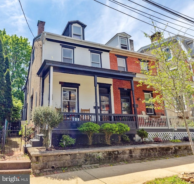 228 Morgan St, Phoenixville, PA 19460 - american foursquare style home with a porch, brick siding, fence, and a chimney