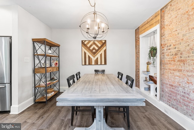 228 Morgan St, Phoenixville, PA 19460 - dining room featuring baseboards, brick wall, an inviting chandelier, and wood finished floors