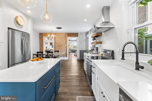 228 Morgan St, Phoenixville, PA 19460 - kitchen featuring a sink, dark wood finished floors, wall chimney exhaust hood, stainless steel appliances, and blue cabinets