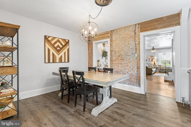228 Morgan St, Phoenixville, PA 19460 - dining area featuring an inviting chandelier, baseboards, brick wall, and wood finished floors