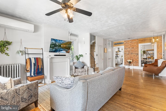 228 Morgan St, Phoenixville, PA 19460 - living area with ceiling fan, a wall mounted air conditioner, a textured ceiling, radiator heating unit, and wood finished floors