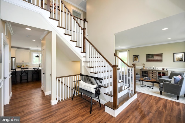 stairs featuring recessed lighting, crown molding, and wood finished floors