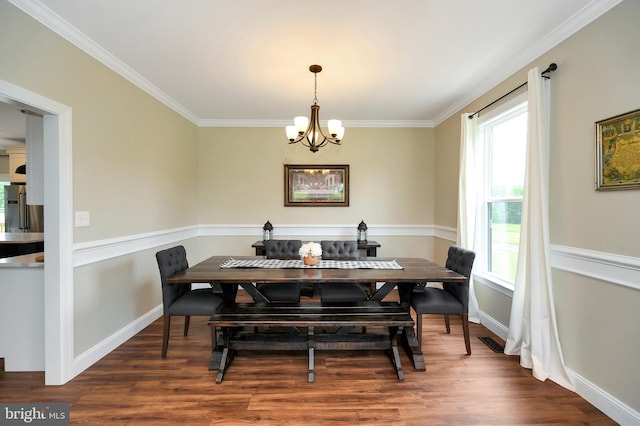dining area featuring crown molding, baseboards, a notable chandelier, and wood finished floors