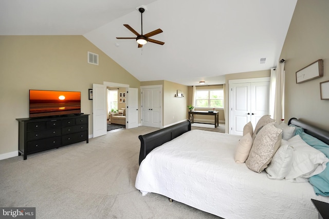 carpeted bedroom featuring visible vents, a ceiling fan, two closets, and high vaulted ceiling