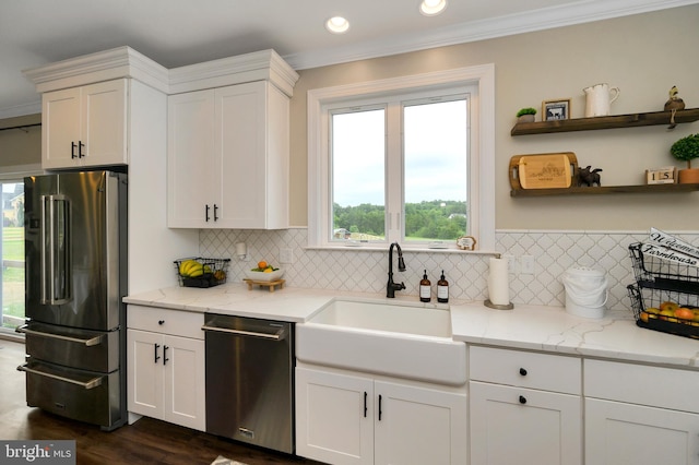 kitchen featuring white cabinetry, appliances with stainless steel finishes, a healthy amount of sunlight, and a sink