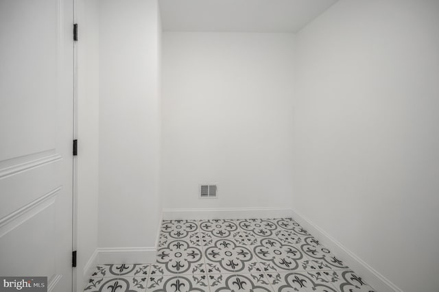 spare room with baseboards and visible vents