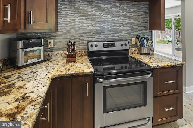 kitchen with backsplash, stainless steel range with electric cooktop, light stone counters, and light tile patterned floors