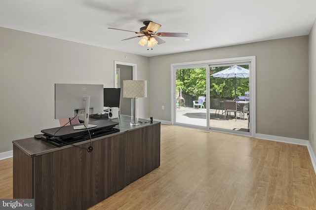 office featuring baseboards, a ceiling fan, and light wood-style flooring