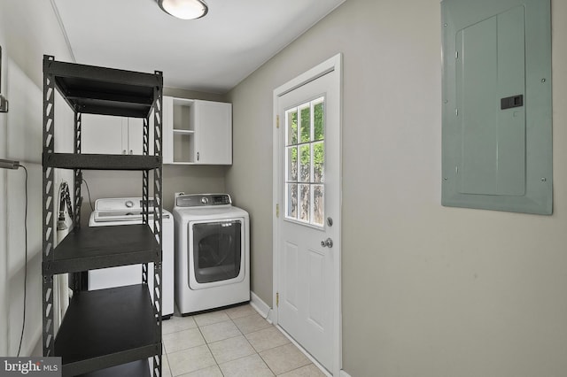 clothes washing area featuring cabinet space, light tile patterned flooring, baseboards, washer and clothes dryer, and electric panel