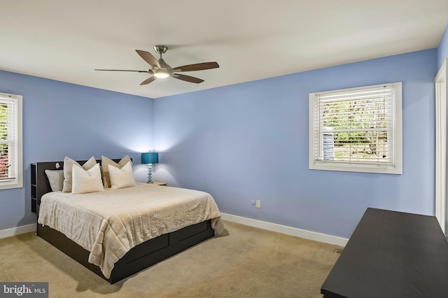 bedroom with baseboards, multiple windows, and light carpet