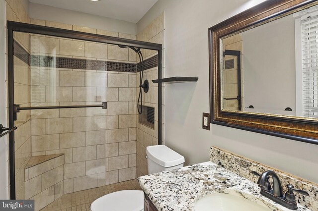full bathroom with vanity, a shower stall, and toilet