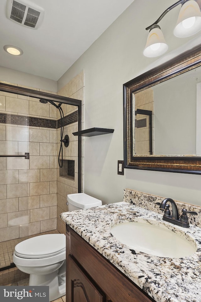 full bathroom with visible vents, tile patterned flooring, a shower stall, vanity, and toilet