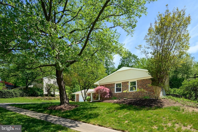ranch-style home featuring brick siding and a front yard