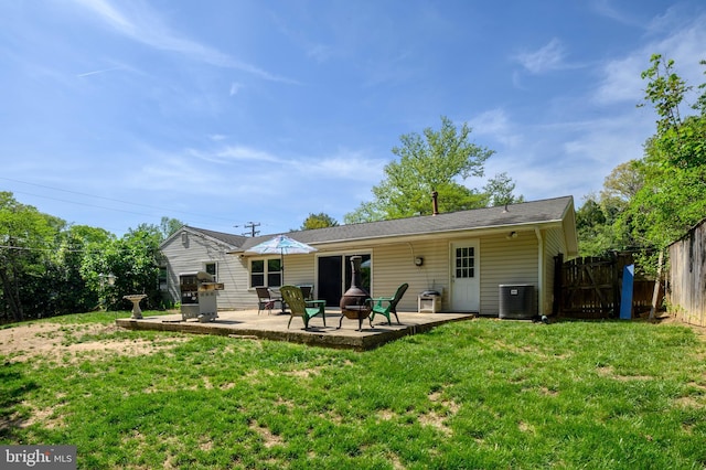 rear view of property with a lawn, a patio, cooling unit, and fence