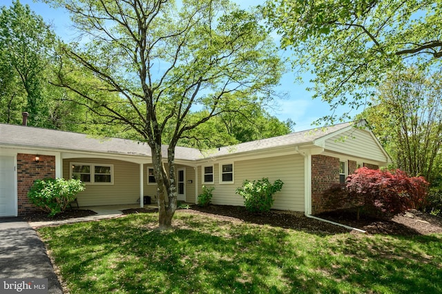ranch-style house featuring brick siding and a front lawn