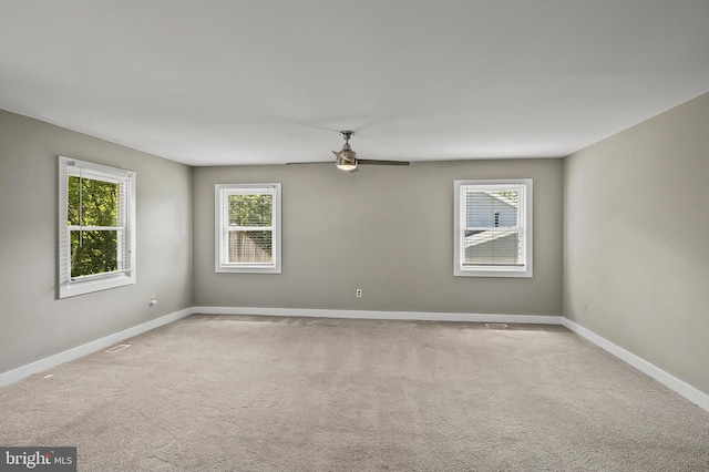carpeted empty room featuring baseboards and ceiling fan
