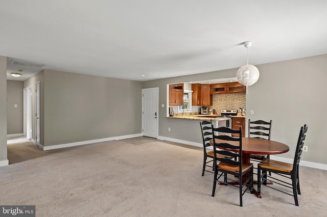 dining area featuring baseboards, visible vents, and light carpet