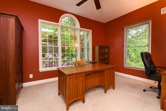 office space featuring ceiling fan, light colored carpet, and baseboards