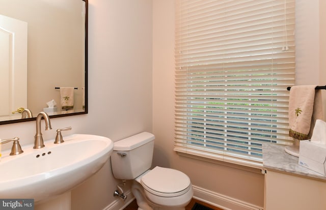 bathroom with a sink, baseboards, and toilet