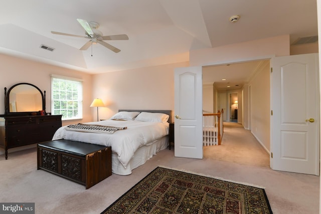 bedroom with carpet flooring, a tray ceiling, and ceiling fan
