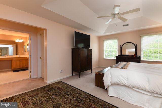 bedroom with light colored carpet, a raised ceiling, a sink, and baseboards