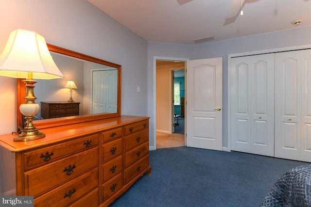 bedroom with dark carpet, a closet, and a ceiling fan