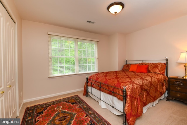 carpeted bedroom featuring baseboards and a closet