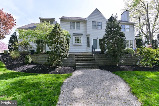 view of front of property with a chimney and a front lawn