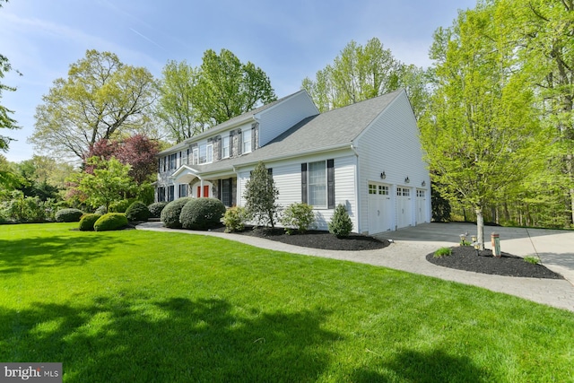 view of front of home with concrete driveway, a front yard, and a garage