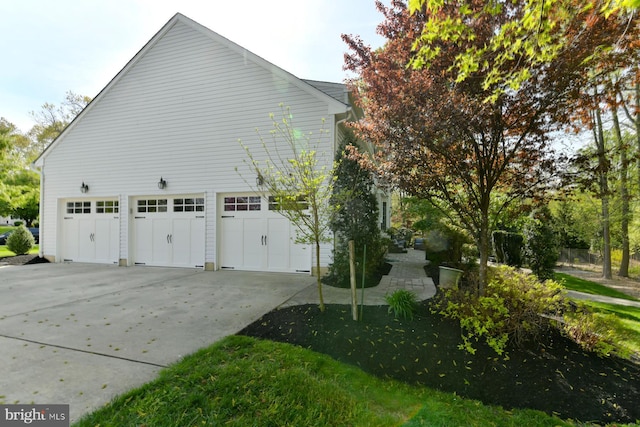 view of side of property with driveway and a garage