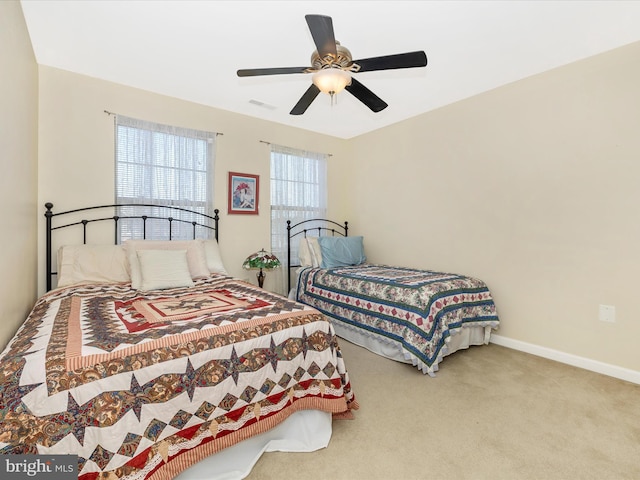 carpeted bedroom with ceiling fan, visible vents, and baseboards