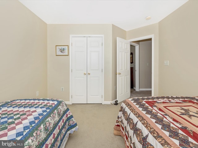 bedroom featuring a closet, baseboards, and light carpet