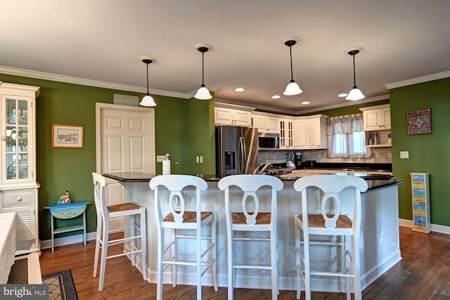kitchen featuring backsplash, stainless steel appliances, baseboards, and dark countertops