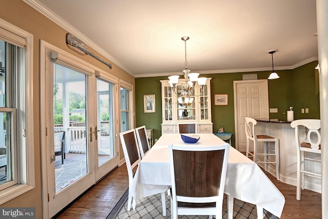 dining room with crown molding, an inviting chandelier, and dark wood-type flooring