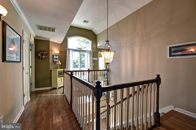 stairway featuring baseboards, lofted ceiling, wood finished floors, and visible vents