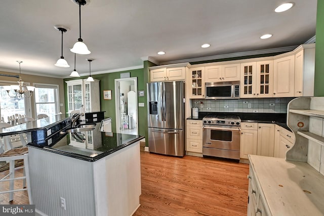 kitchen featuring crown molding, a sink, light wood finished floors, and appliances with stainless steel finishes