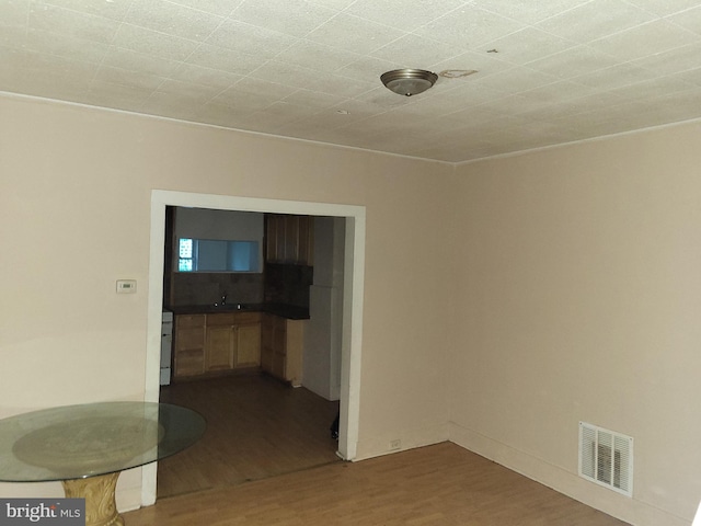 423 Furrow St, Baltimore, MD 21223 - unfurnished room with dark wood-style flooring, visible vents, and a sink