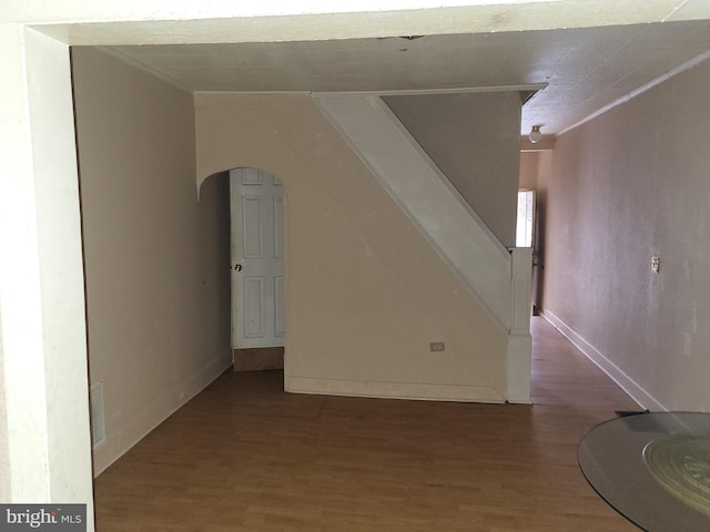 423 Furrow St, Baltimore, MD 21223 - unfurnished living room featuring ornamental molding, wood finished floors, baseboards, stairway, and arched walkways