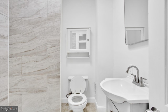 bathroom featuring vanity, baseboards, and toilet