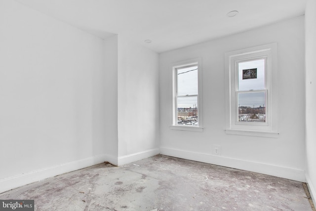 empty room featuring baseboards and unfinished concrete floors