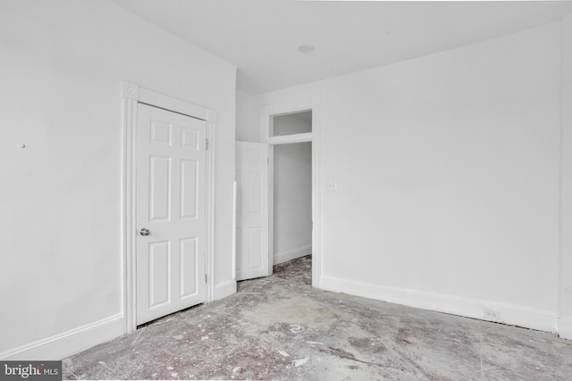 unfurnished bedroom with baseboards and unfinished concrete floors