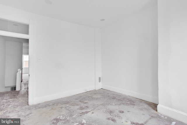empty room featuring concrete flooring and baseboards