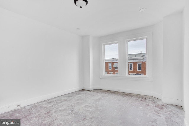 unfurnished room with baseboards
