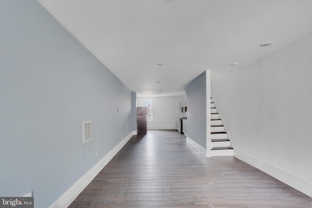 corridor with stairway, baseboards, wood finished floors, and visible vents