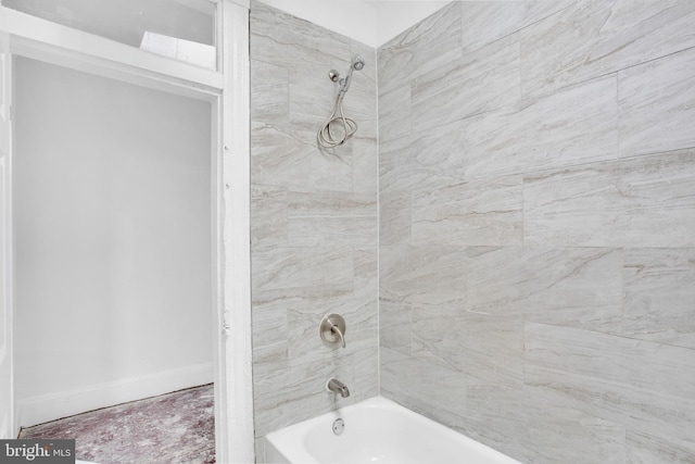 bathroom with baseboards and  shower combination