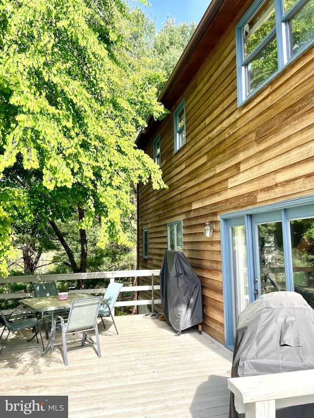 wooden deck featuring outdoor dining area and grilling area
