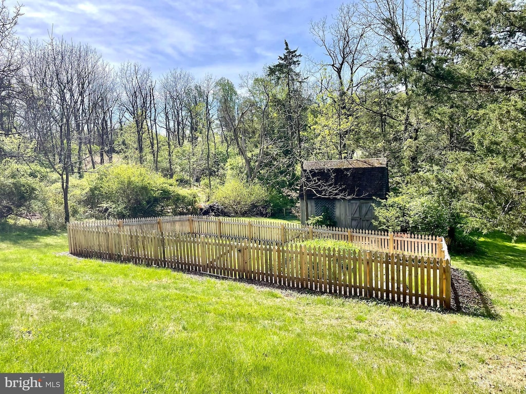 view of yard with a barn, fence, and an outbuilding