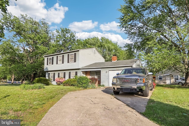 colonial home featuring driveway, a chimney, and a front yard