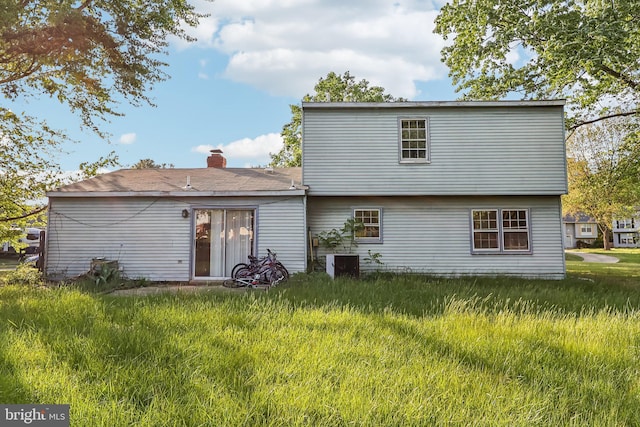 back of property featuring central AC unit and a chimney